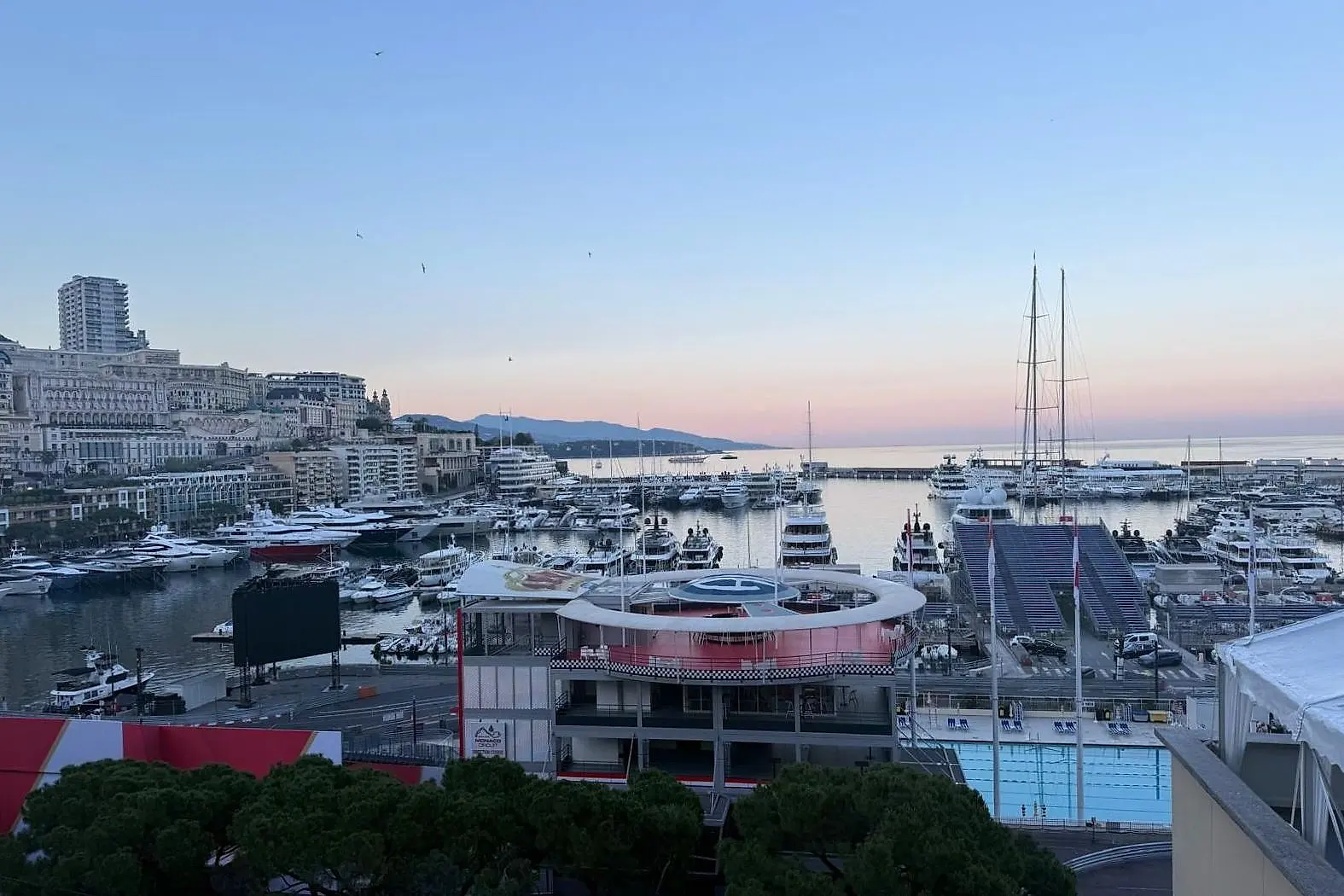 The harbour at first light, the town and the coast in a pink haze.