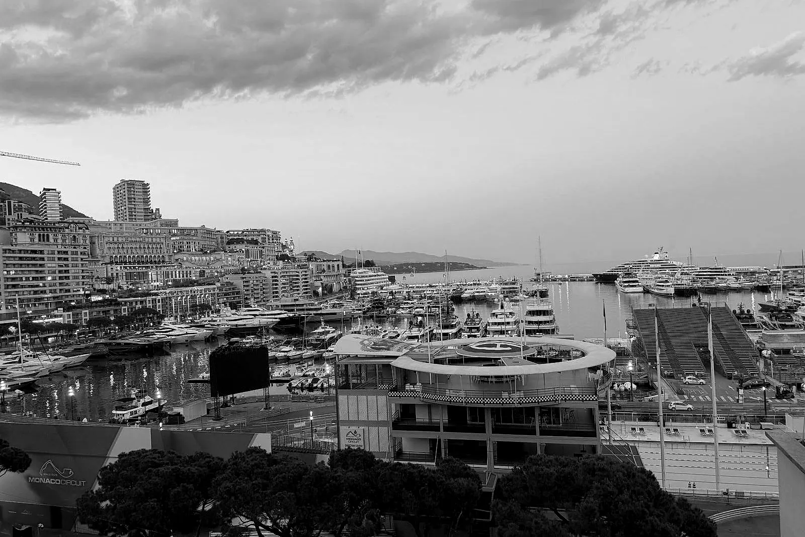 In bianco e nero: il porto al crepuscolo, i palazzi di Monte-Carlo che salgono sulla collina a sinistra.